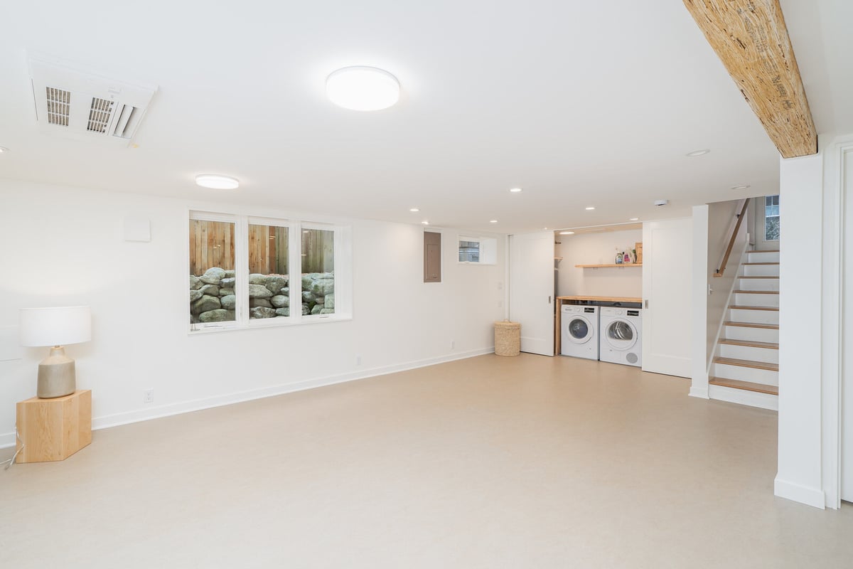 Laundry nook with washer and dryer in a modern basement remodel by CB Construction, Seattle