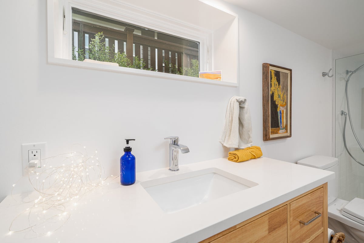 Modern bathroom vanity with wooden drawers in a remodeled basement by CB Construction in Seattle