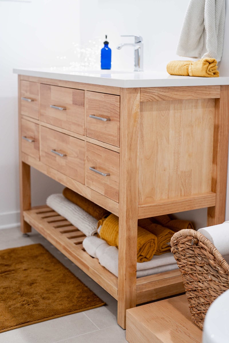 Natural wood bathroom vanity with folded towels in a Seattle basement remodel by CB Construction