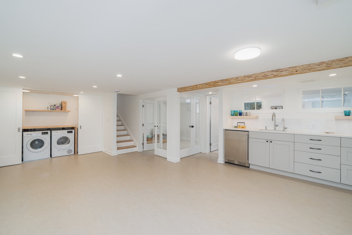 Open basement living space with modern finishes in a Seattle home by CB Construction