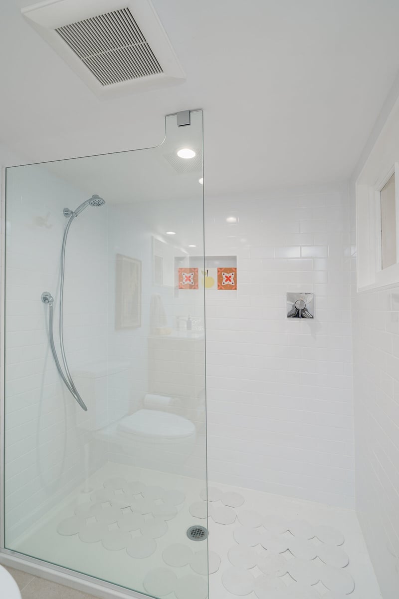 Seattle basement bathroom remodel by CB Construction featuring a glass shower and built-in tile accents