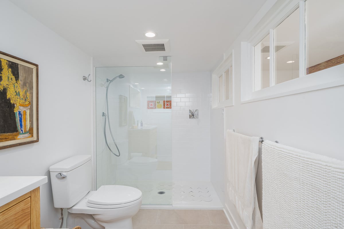 Seattle basement bathroom remodel by CB Construction with a glass shower and framed artwork