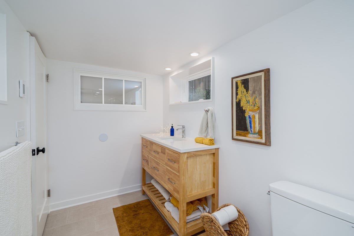 Seattle basement remodel bathroom by CB Construction with a wooden vanity and decorative accents