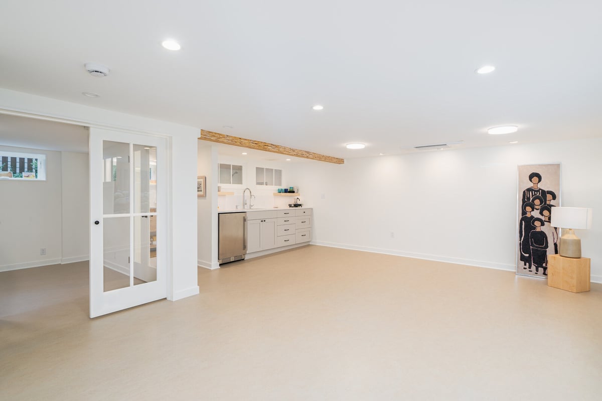 Spacious basement living area with kitchenette in a Seattle remodel by CB Construction